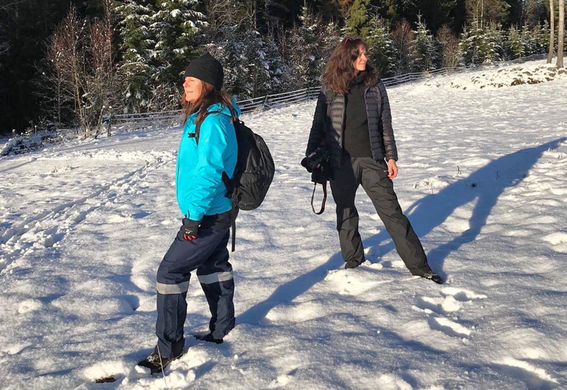 2 kvinnor står i solen i snön i Gårdsjötorp